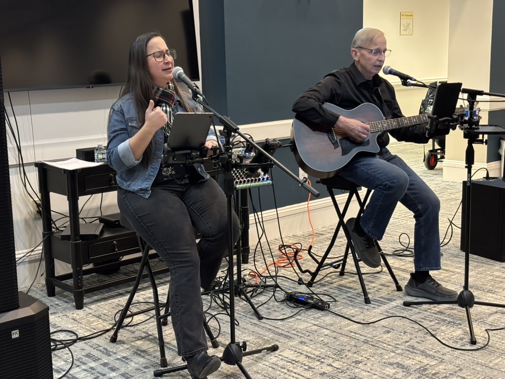 Jess singing and Keith on guitar during a concert