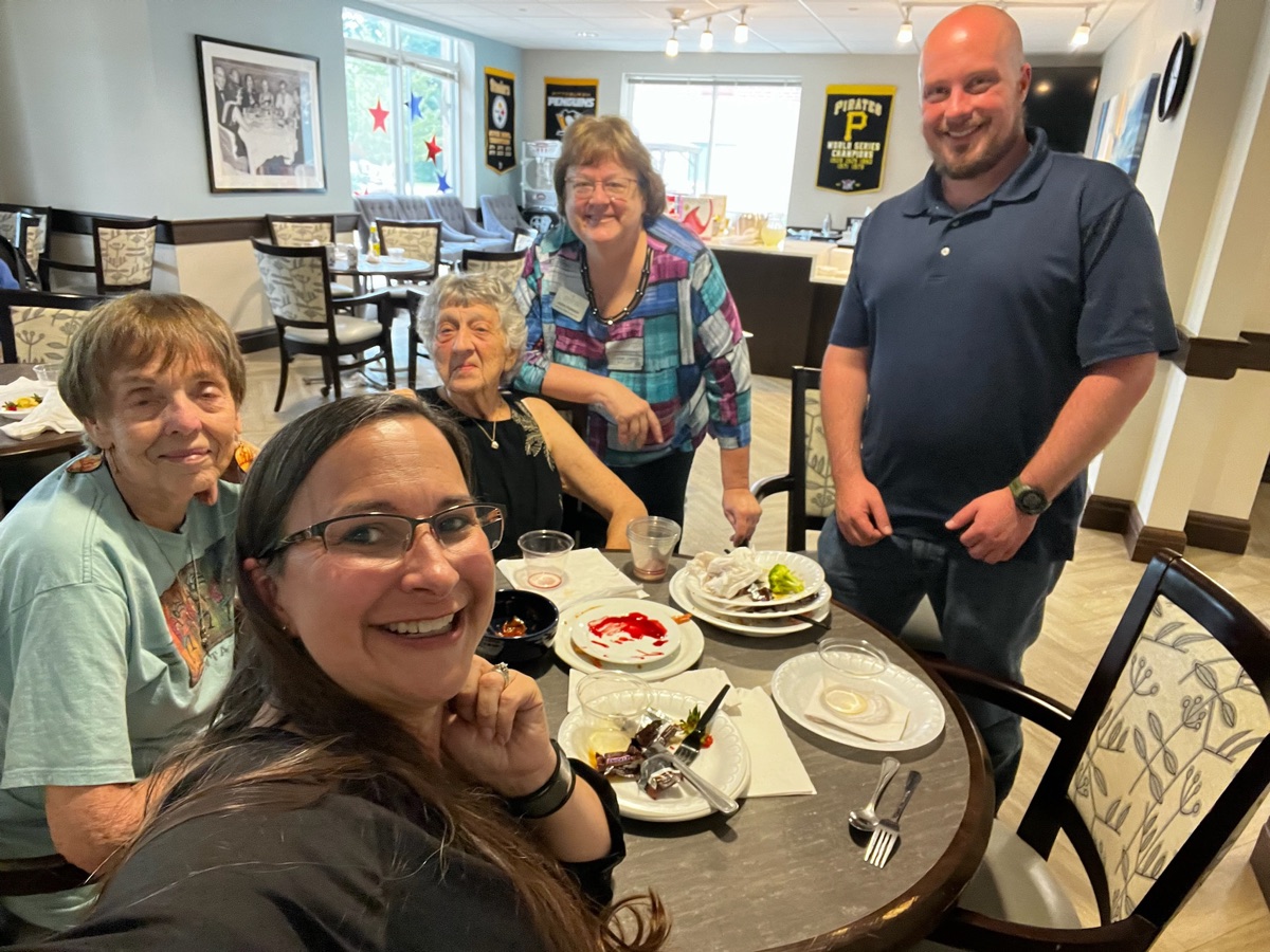 The team sharing a meal and conversation with residents in the dining room
