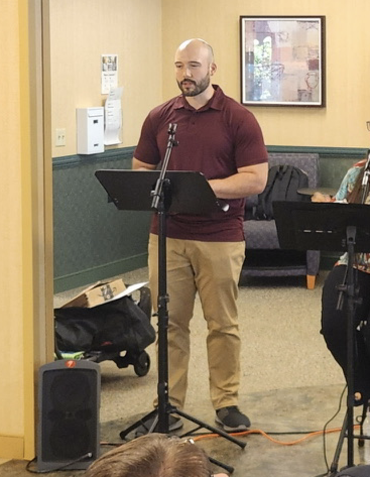 Will Sorge reading from a music stand during a nursing home concert